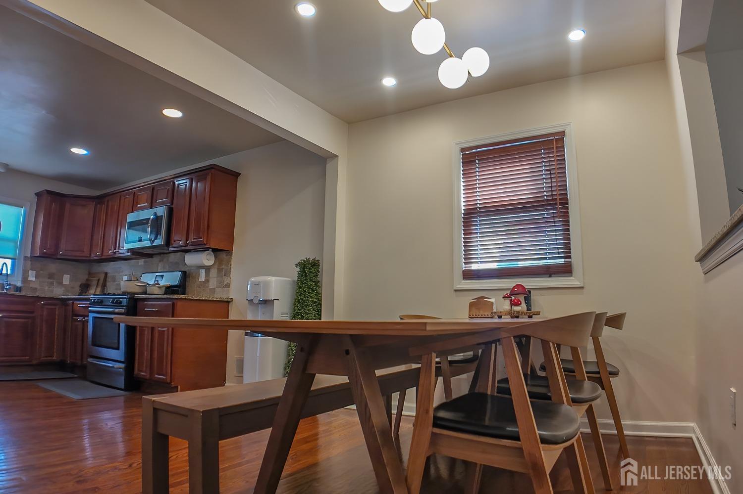 202 Jackson Avenue Edison, NJ 08837 - Photo 10 of 35 a kitchen with stainless steel appliances granite countertop a stove top oven a sink dishwasher and a dining table with wooden cabinet