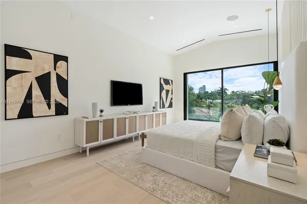 a living room with furniture a flat screen tv and a floor to ceiling window