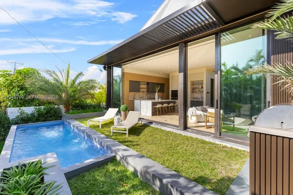 a view of a house with backyard and sitting area