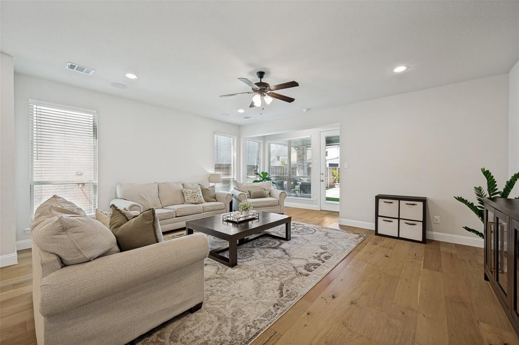 8440 Colburn The Colony, TX 75056 - Photo 8 of 34 Bright and inviting living room featuring beautiful wide plank wood floors, recessed lighting, and expansive windows that fill the space with natural light.