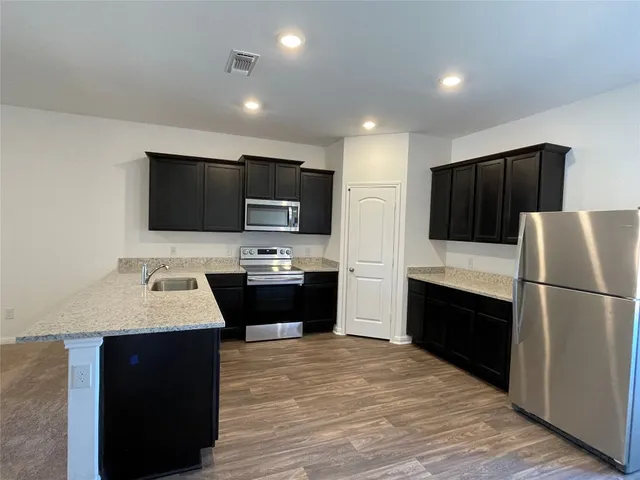a kitchen with a refrigerator stove and sink
