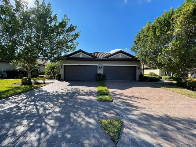 a front view of a house with a garden and yard