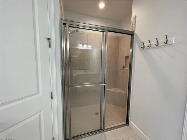 a spacious bathroom with a granite countertop sink a mirror and a shower