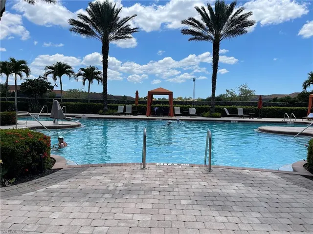 a view of a swimming pool with tables and chairs