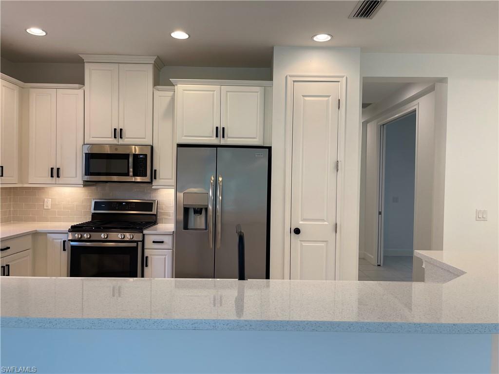 8217 Lucello Terrace West Naples, FL 34114 - Photo 6 of 41 a kitchen with a refrigerator and a stove top oven