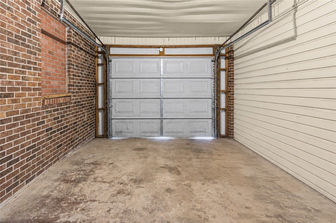 322 Tribble Street Honea Path, SC 29654 - Photo 34 of 35 Functional vehicle storage options include this garage space with concrete flooring and durable brick walls.