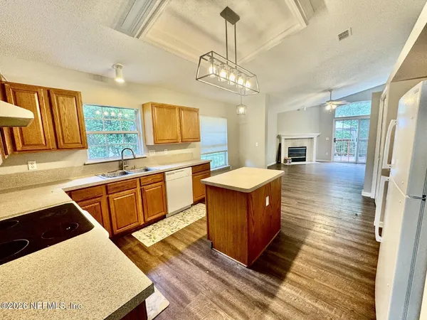 a kitchen with stainless steel appliances granite countertop a sink a stove top oven a counter space and cabinets
