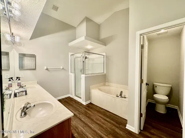 a bathroom with a sink a toilet and shower a mirror