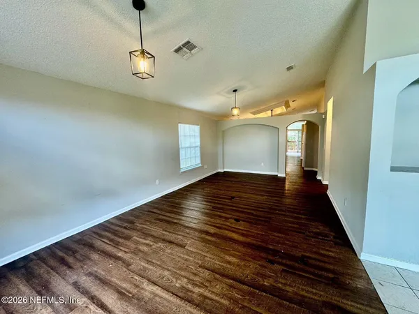 a view of empty room with wooden floor