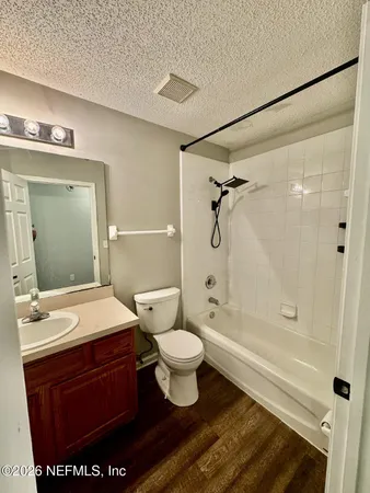 a bathroom with a sink a toilet a mirror and shower
