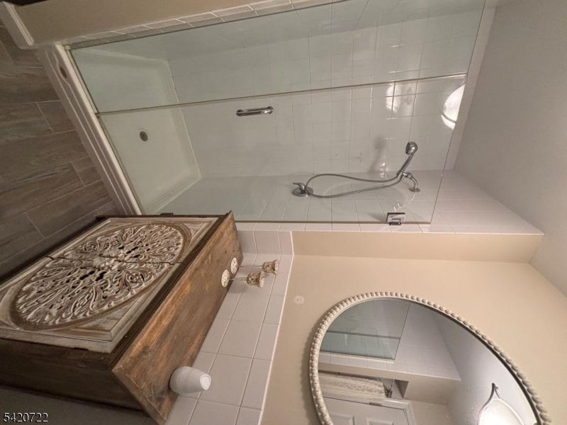 1935 Oceanfront, Unit 20 Seaside Heights, NJ 08751 - Photo 13 of 16 a bathroom with a sink and mirror