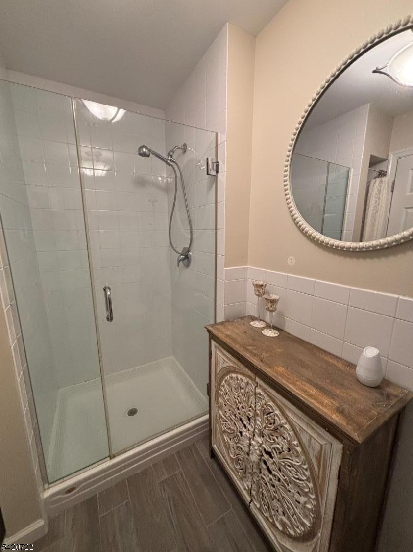 1935 Oceanfront, Unit 20 Seaside Heights, NJ 08751 - Photo 8 of 16 a bathroom with a granite countertop sink a mirror and shower