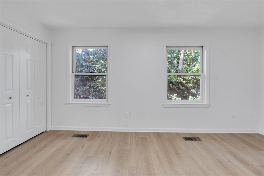111 Brigham Street, Unit 13B Hudson, MA 01749 - Photo 13 of 23 a view of an empty room with wooden floor and a window