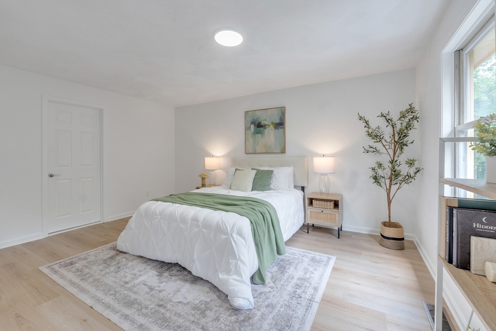 111 Brigham Street, Unit 13B Hudson, MA 01749 - Photo 18 of 23 a bedroom with a large bed and potted plant