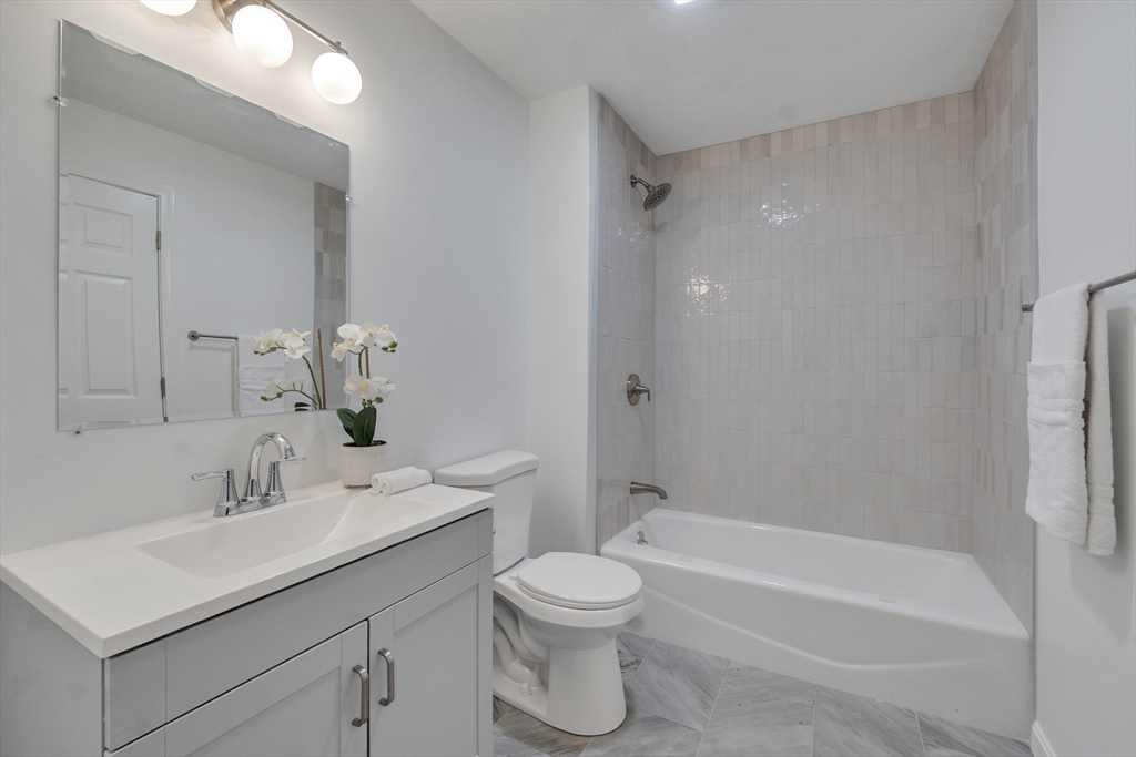 111 Brigham Street, Unit 13B Hudson, MA 01749 - Photo 22 of 23 a bathroom with a sink toilet a vanity and bathtub
