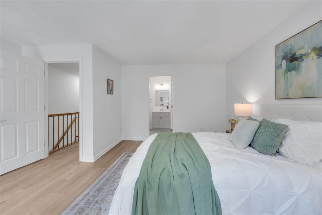 111 Brigham Street, Unit 13B Hudson, MA 01749 - Photo 23 of 23 a bedroom with a bed and painting on the wall