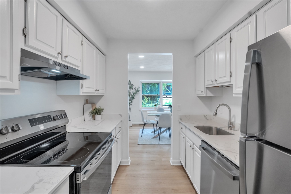 111 Brigham Street, Unit 13B Hudson, MA 01749 - Photo 6 of 23 a kitchen with granite countertop a stove sink and refrigerator