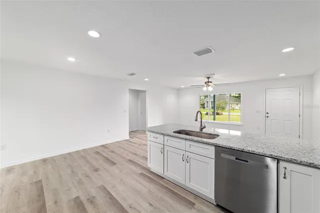 a view of a kitchen with a refrigerator and wooden floor