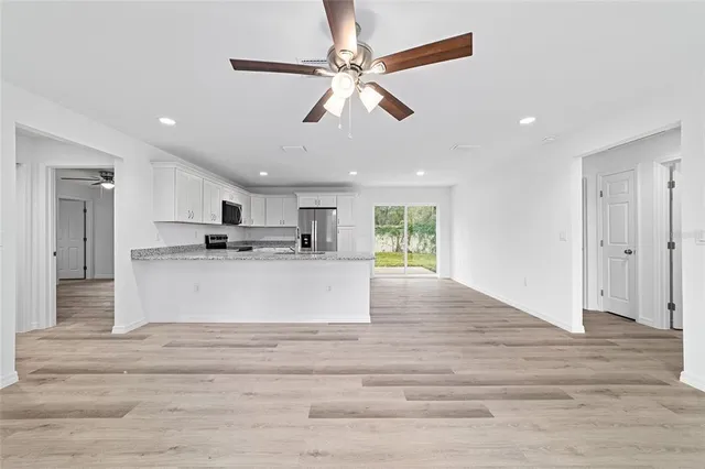 a view of kitchen with granite countertop cabinets and refrigerator