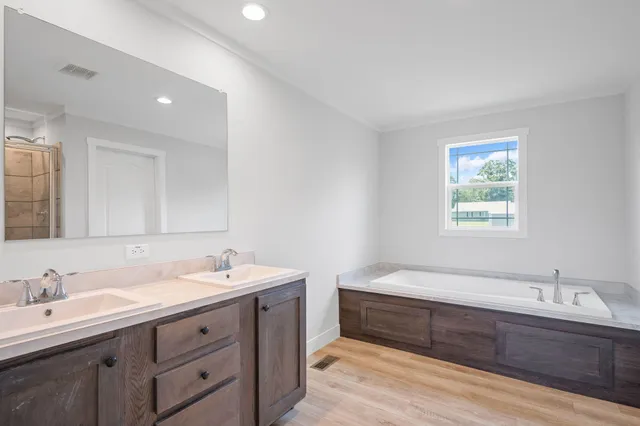 a spacious bathroom with a double vanity sink and a bathtub