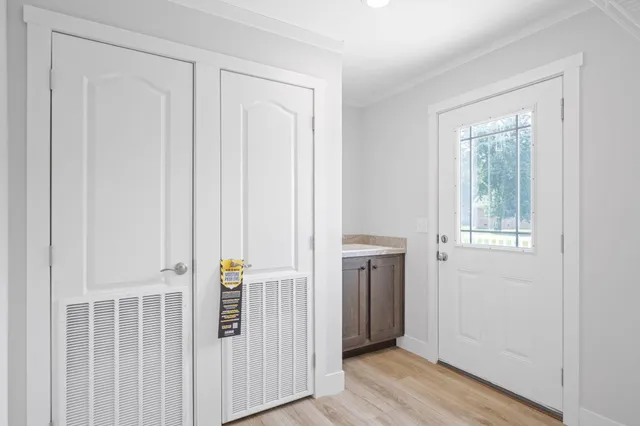 a view of a hallway with wooden floor and entryway