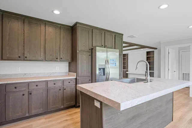 a kitchen with a sink a refrigerator and cabinets