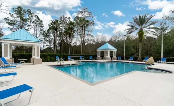 a view of a house with pool and sitting area