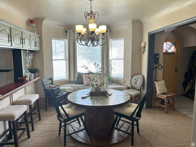 40 South State Street Scipio, UT 84656 - Photo 15 of 39 Dining area featuring plenty of natural light, arched walkways, light colored carpet, and a chandelier