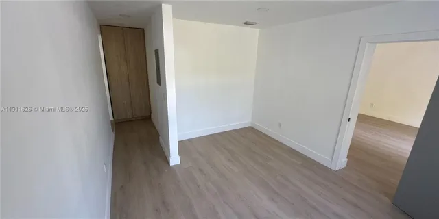 an empty room with wooden floor and closet