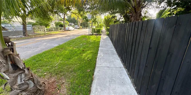 a front view of a house with a yard and potted plants