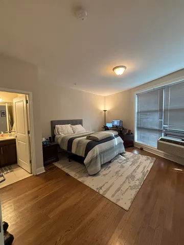 a bedroom with a bed and wooden floor