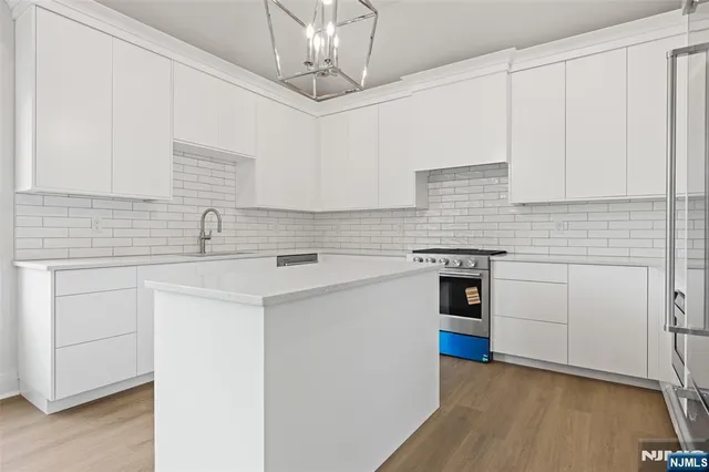 a kitchen with stainless steel appliances granite countertop a sink a stove and cabinets