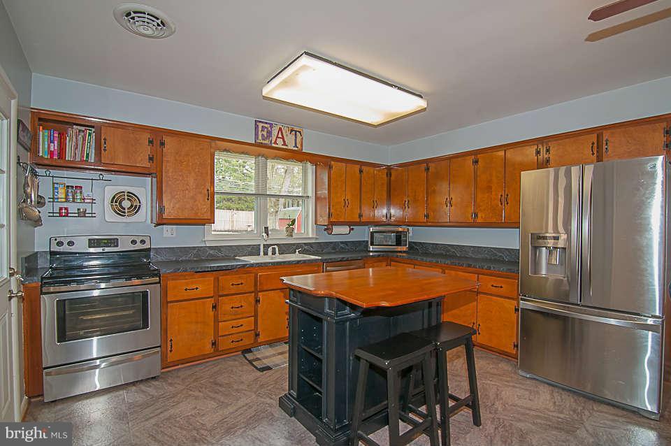 3721 Macalpine Road Ellicott City, MD 21042 - Photo 2 of 22 a kitchen with stainless steel appliances granite countertop a stove refrigerator and cabinets