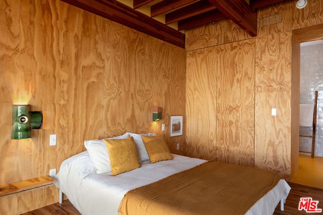 a bed sitting in a bedroom next to a window