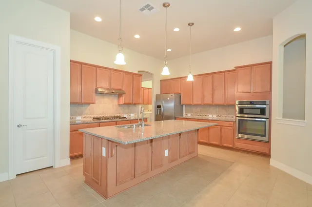 a large kitchen with stainless steel appliances lots of white cabinets