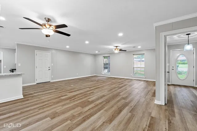 a view of an empty room and window and wooden floor