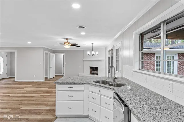 a view of kitchen with granite countertop refrigerator stove microwave and cabinets