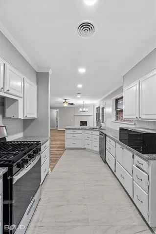 a kitchen with stainless steel appliances kitchen island granite countertop a stove and a sink