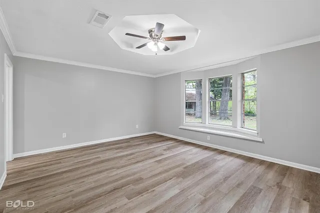 a view of an empty room with window and wooden floor