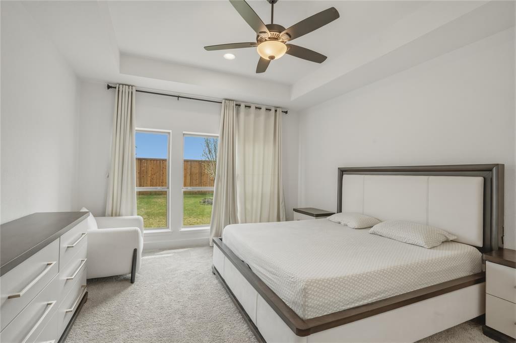 908 Maple Leaf Lane Haslet, TX 76052 - Photo 18 of 40 a bedroom with a large bed and a chandelier fan