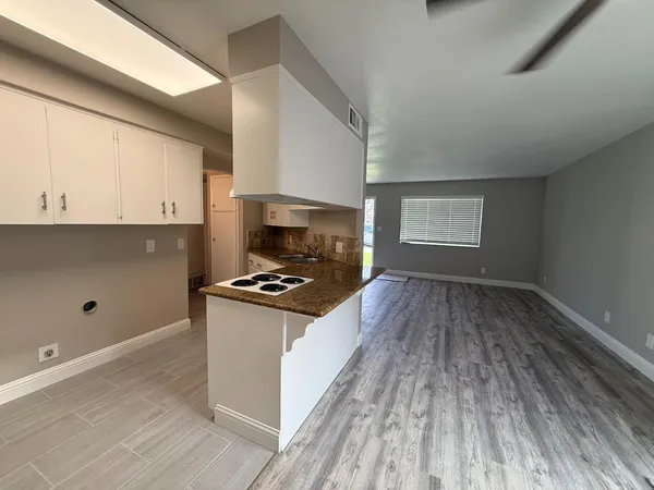 a kitchen with granite countertop a stove and a wooden floors