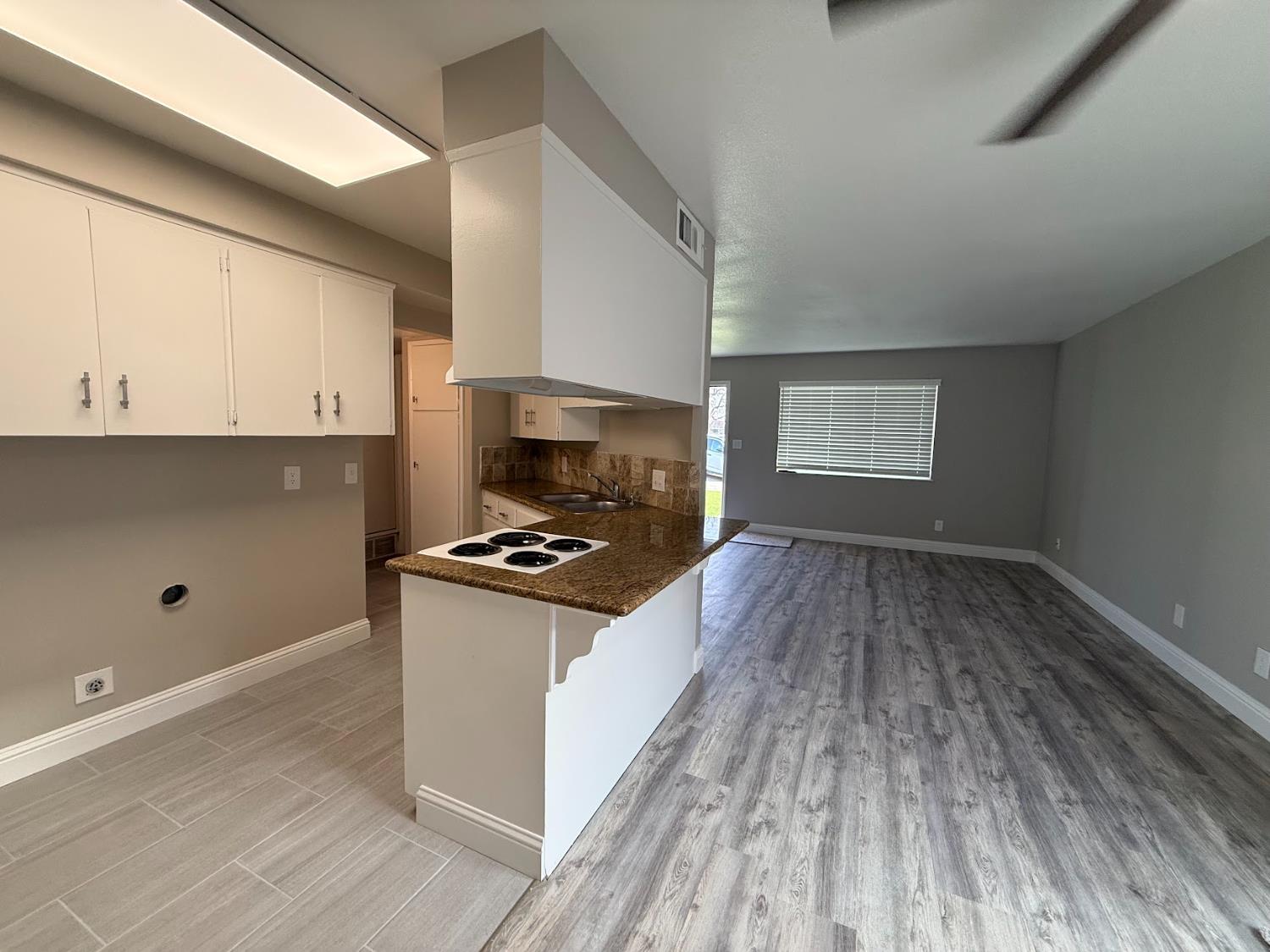 1205 F Street Reedley, CA 93654 - Photo 23 of 33 a kitchen with granite countertop a stove and a wooden floors