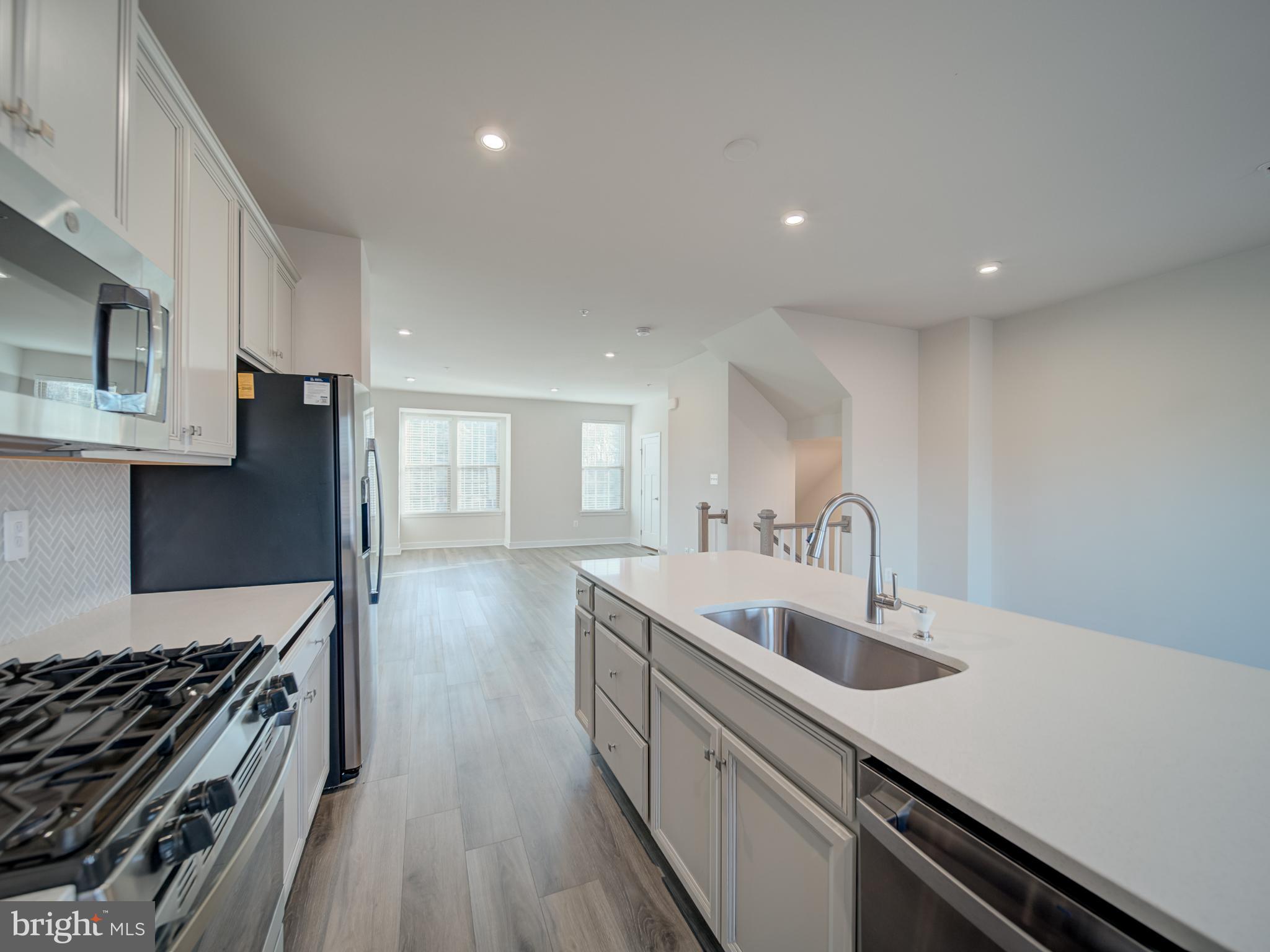 9502 Autumn Berry Place Montgomery Village, MD 20886 - Photo 11 of 36 a kitchen with counter top space stainless steel appliances and wooden floor