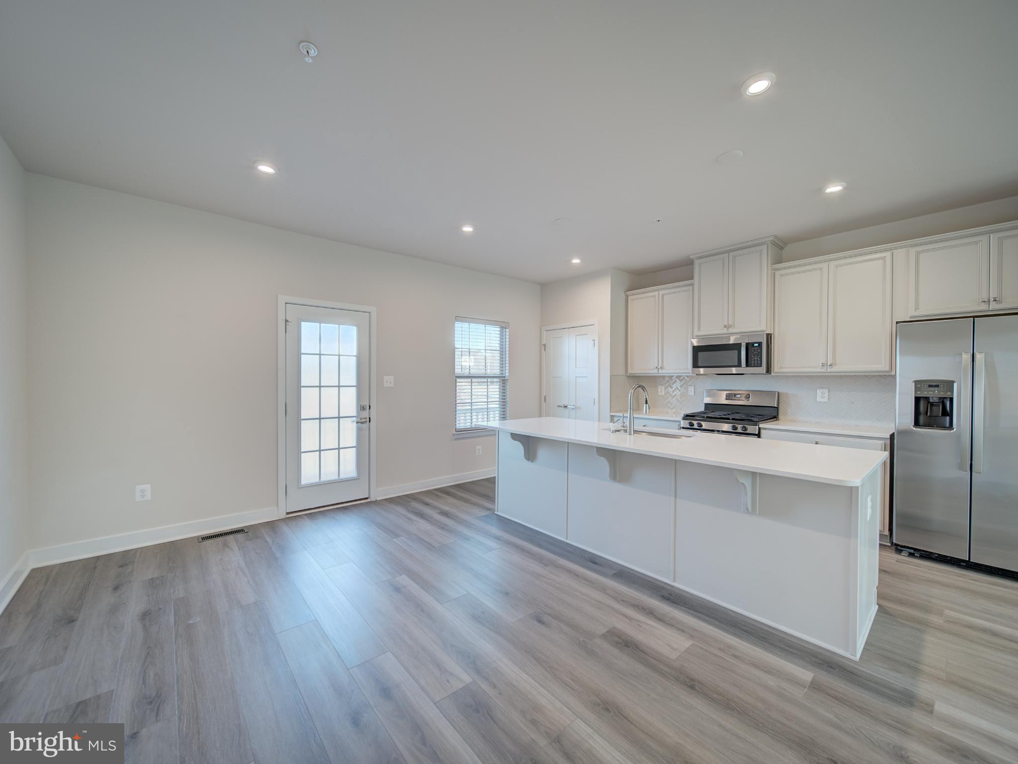 9502 Autumn Berry Place Montgomery Village, MD 20886 - Photo 13 of 36 a kitchen with stainless steel appliances granite countertop a stove a sink white cabinets and a refrigerator