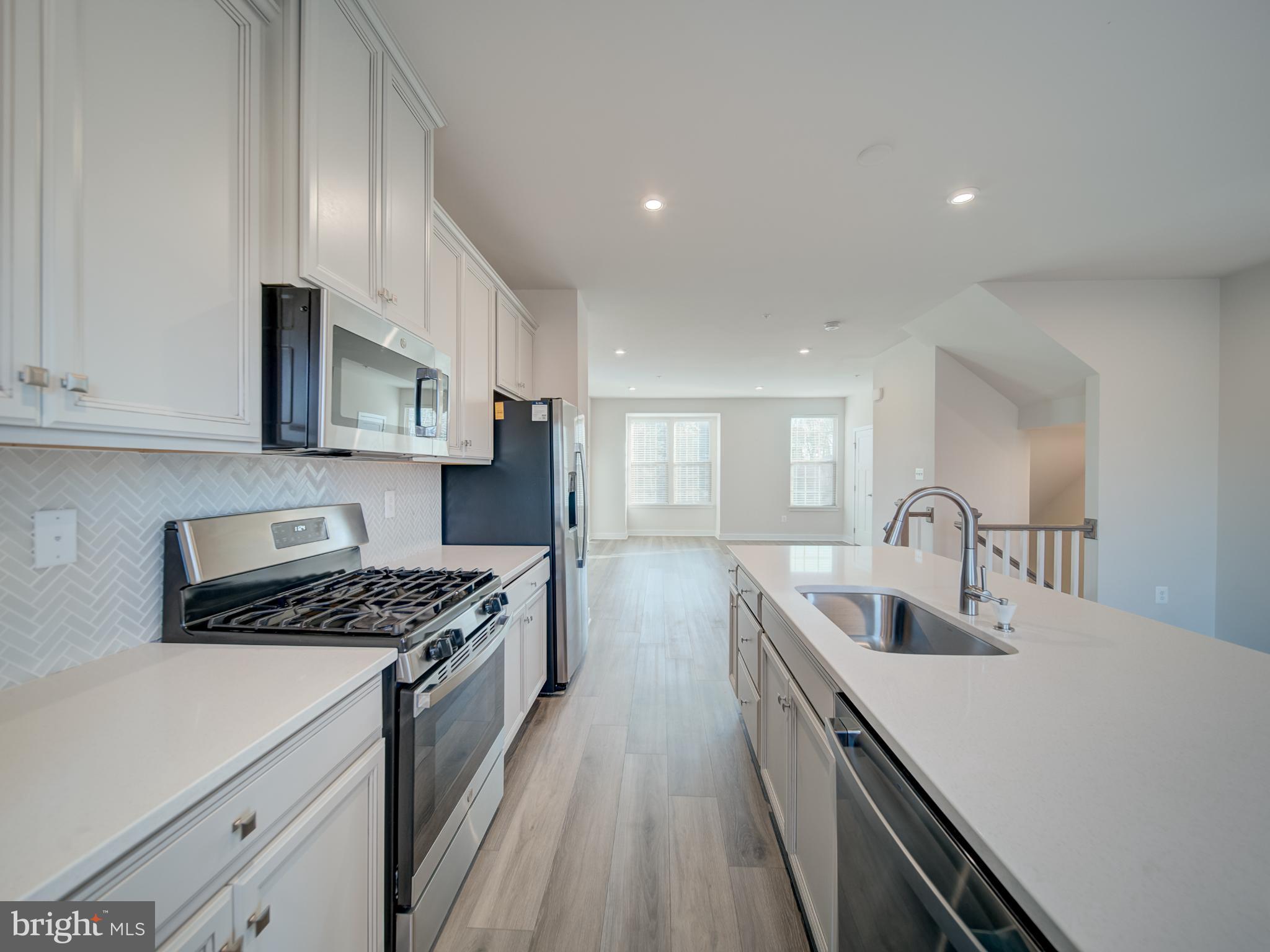 9502 Autumn Berry Place Montgomery Village, MD 20886 - Photo 15 of 36 a kitchen with stainless steel appliances granite countertop a sink stove and refrigerator