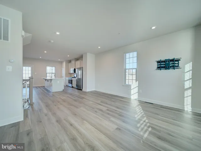a view of empty room with wooden floor and windows