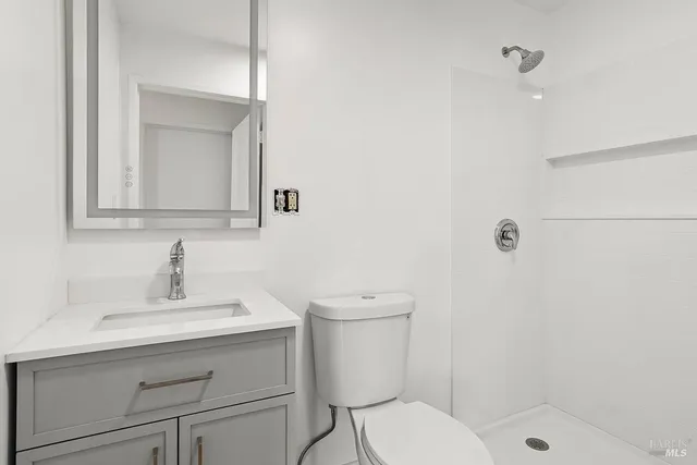 a bathroom with a sink a toilet and shower
