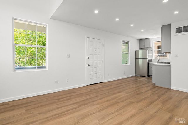 wooden floor in an empty room with a kitchen