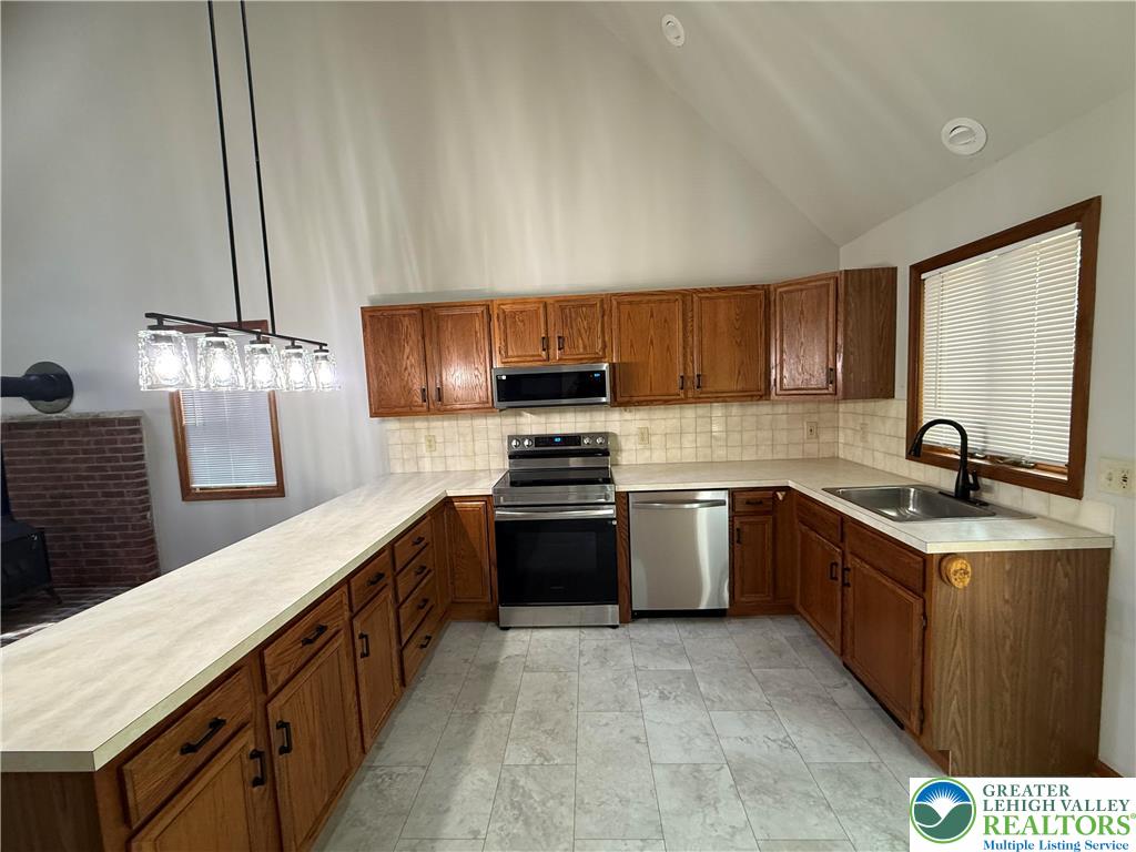 184 Doe Loop Bushkill, PA 18324 - Photo 12 of 18 a kitchen with stainless steel appliances granite countertop a sink stove and refrigerator