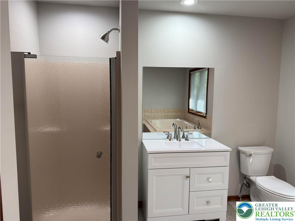 184 Doe Loop Bushkill, PA 18324 - Photo 17 of 18 a bathroom with a toilet sink vanity and mirror
